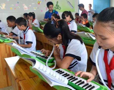 忠庄镇忠庄小学乡村学校少年宫的孩子在学校练习口风琴